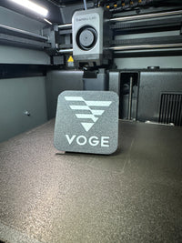 Tapa decorativa con logo Voge impresa en 3D para el soporte antirrobo
