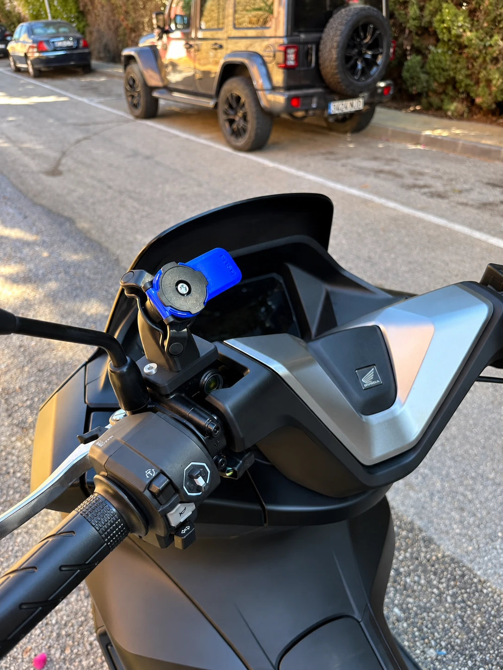 Detalle del soporte Quad Lock sobre la tapa del depósito de líquido de frenos en Honda PCX