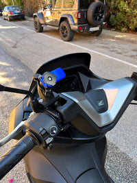 Detalle del soporte Quad Lock sobre la tapa del depósito de líquido de frenos en Honda PCX